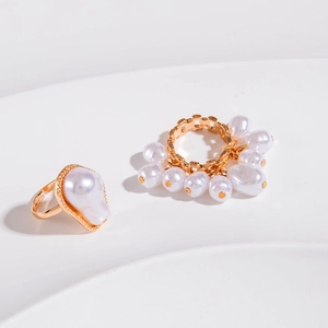 Set of two gold alloy rings with baroque irregular pearls and镂空 openwork design