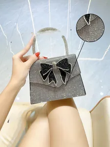 Detailed view of shimmering silver rhinestones and elegant black bow on a bridal clutch