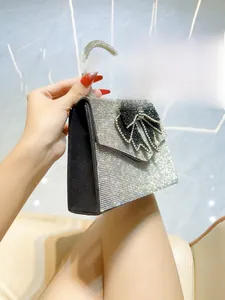 Close-up of a silver rhinestone evening bag with a large black crystal bow decoration