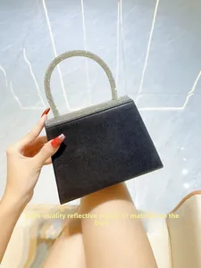 Detail of high-quality reflective polyester back on black evening bag with rhinestones