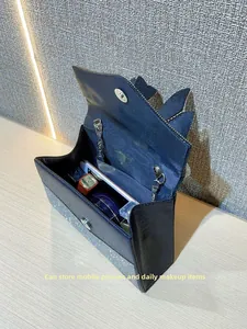 Interior detail of swallowtail handbag showing storage space for phone and makeup