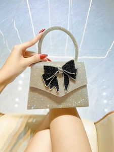 Detail of silver rhinestone evening bag with oversized sparkling butterfly bow