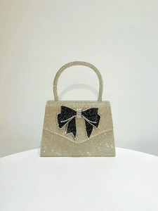 Detailed view of the luxury rhinestone evening bag featuring a large black crystal bow