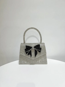 Macro shot of silver rhinestone evening bag with a black and white crystal bow design