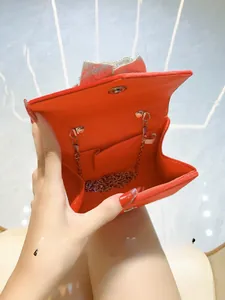 Detailed interior of red velvet evening bag with silver bow and metal chain strap