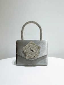 Detail of silver velvet evening bag with crystal rose and rhinestone handle