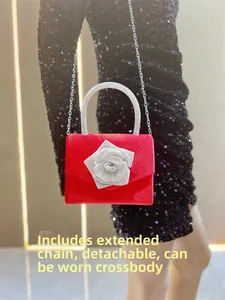 Detail of red velvet evening clutch featuring a large rhinestone rose and detachable chain