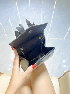 Mini black textured evening bag with unique leaf design and metal chain strap inside