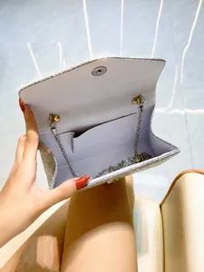 Silver glitter evening clutch featuring internal storage compartment and chain strap