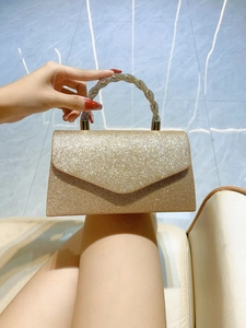 Close-up of golden sequin clutch bag with sparkling rhinestone encrusted round handle