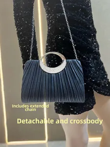 Detail of pleated black evening bag with crystal-encrusted silver handle and chain