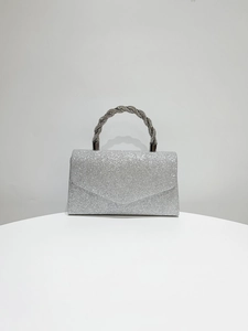 Close-up of sparkling silver evening clutch with rhinestone handle and glittery finish