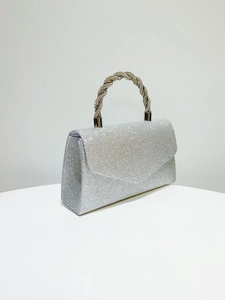 Detail of silver glitter evening bag featuring a luxury twisted rhinestone-encrusted handle