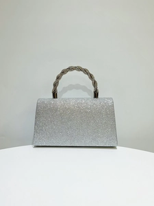 Detailed view of silver glitter evening clutch with twisted rhinestone handle and texture