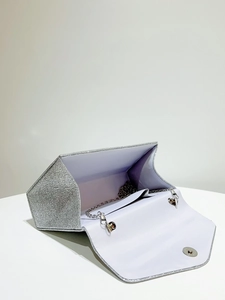 Detail of silver sequin evening clutch bag showing lavender interior and chain strap