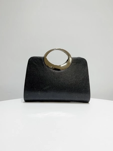 Detail showing the fine vertical texture and sleek silver metal handle of this black evening bag