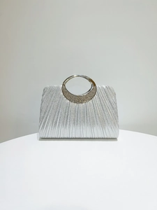 Detail of silver pleated evening clutch bag with rhinestone crescent metal handle