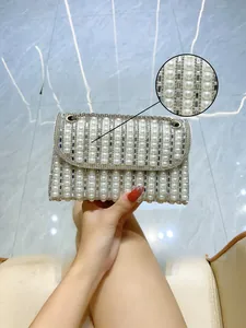 Detail of luxury evening bag featuring high-luster pearls and sparkling rhinestones inlay