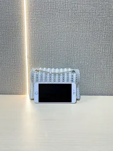 Close-up of sparkling evening clutch featuring vertical pearl rows and sequin details