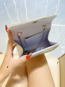 Close-up of silver glitter evening bag interior showing large opening and chain strap