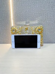 Detail view of gold evening clutch bag with heavy diamond inlays and floral stone patterns