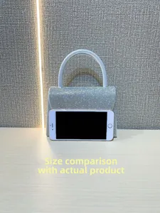 Size comparison of silver sparkly mini evening bag next to a smartphone