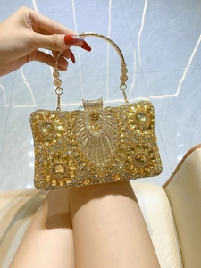 Detail of luxury evening bag with champagne rhinestones and floral metal handle
