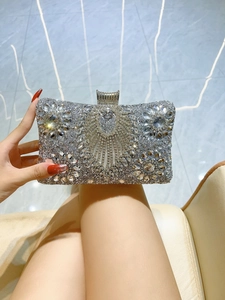 Detailed shot of a silver rhinestone evening clutch bag held by a model for gala events