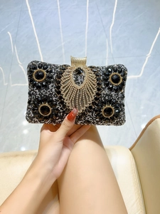 Detail of evening clutch with black rhinestones, floral gems, and gold metal clasp