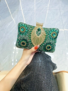 Close-up of emerald green rhinestone evening clutch with intricate floral patterns