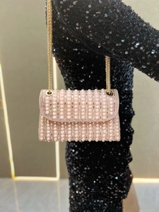 Detail of pink pearl evening bag with sparkling crystals and elegant gold chain strap