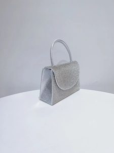 Detail of silver rhinestone evening clutch bag with sparkling stones and metal handle