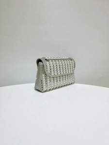 Detail showing faux pearl and rhinestone inlay on silver-tone bridal clutch bag