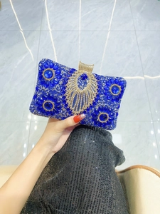 Detail of royal blue rhinestone clutch bag with gold fan-shaped crystal clasp