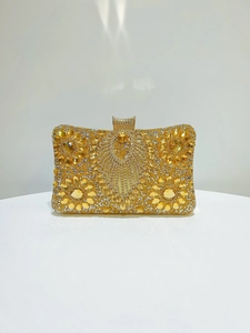Macro shot of gold evening clutch featuring intricate floral crystal patterns and sparkles