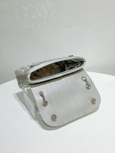 Detail of silver evening clutch featuring inlaid pearls, rhinestones and magnetic closure