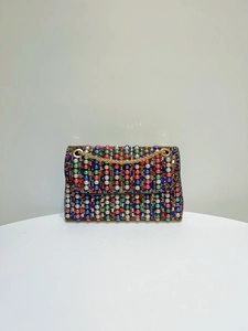 Detail of evening clutch featuring vibrant colorful beads and gold metal chain strap