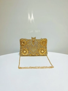 Detail of luxury evening clutch bag featuring radiant gold rhinestones and floral pattern