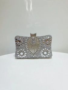 Macro shot of silver evening clutch with sparkling rhinestones and floral crystal pattern