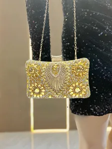 Detailed close-up of a luxury gold evening bag with floral rhinestones and gold chain