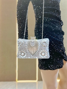 Macro detail of luxury silver evening clutch showing intricate rhinestone floral pattern