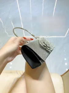 Detail of silver rhinestone evening bag with sparkling flower buckle and round metal handle