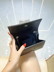Detail showing the large opening and internal storage of the rhinestone bow evening bag