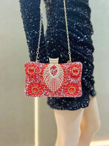 Detail of red crystal evening bag with floral patterns on black sequin dress
