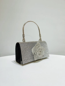 Detailed macro of silver rhinestone evening bag with intricate 3D floral crystal detail