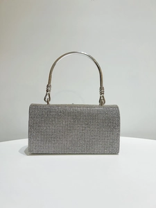 Detailed macro view of silver rhinestone handbag with elegant twisted metal handle