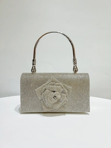 Detailed macro view of the sparkling 3D rhinestone rose on this silver evening clutch bag
