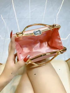 Top view of open pink satin evening clutch bag with gold frame and gem clasp