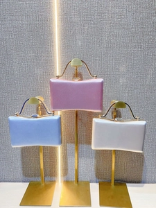 Elegant satin evening clutch bags in pink, blue, and cream with golden metal handles