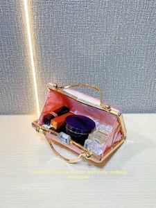 Pink satin evening clutch with gold metal handle showing space for cosmetics and phone